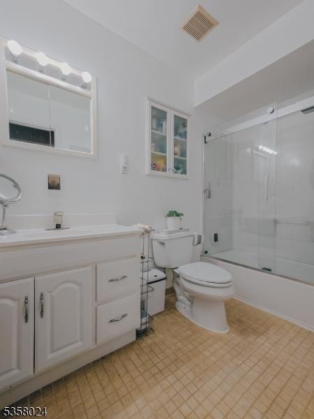 full bathroom with toilet, vanity, bath / shower combo with glass door, and tile patterned floors