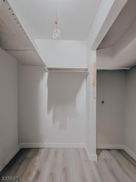 walk in closet featuring wood finished floors