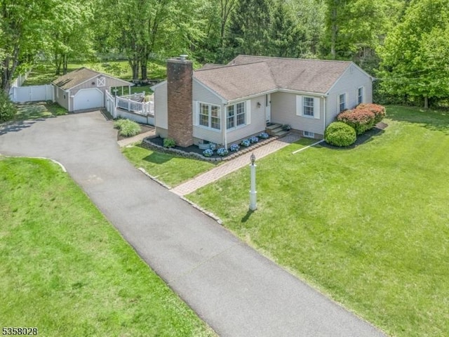 ranch-style home featuring a chimney, an outdoor structure, asphalt driveway, and a detached garage