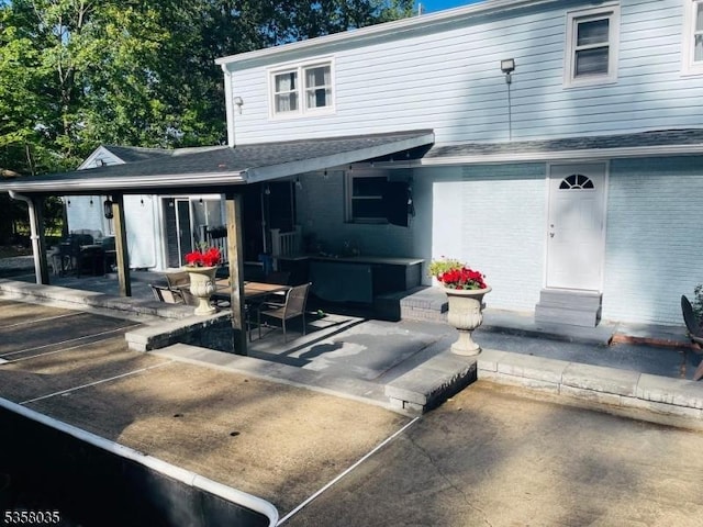 64 Dater St, North Haledon Boro, NJ 07508 - rear view of property featuring a patio, brick siding, and a shingled roof
