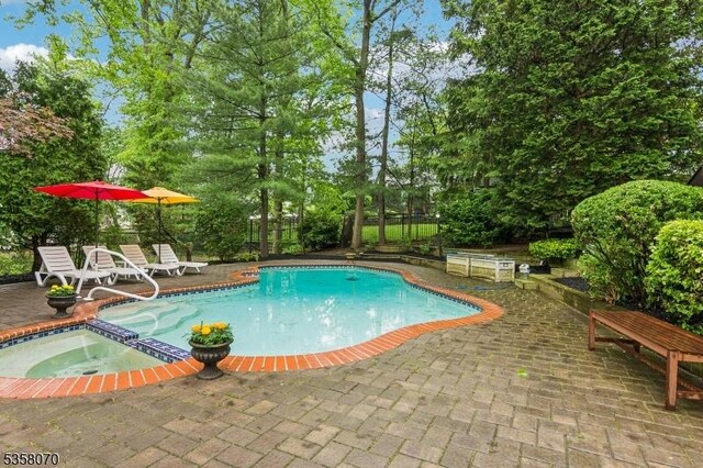 95 Union Ave, Edison Twp, NJ 08820 - view of pool featuring a patio area, a fenced backyard, a pool with connected hot tub, and view of wooded area