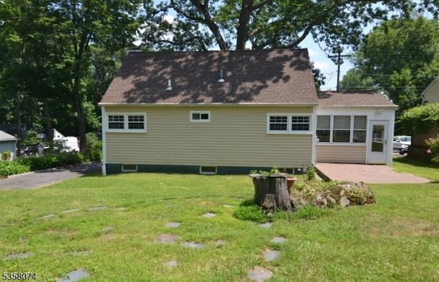 back of property featuring a lawn and a patio