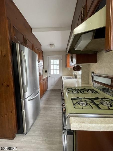 277 Watchung Ave, North Plainfield Boro, NJ 07060 - kitchen with appliances with stainless steel finishes, under cabinet range hood, light countertops, and a sink