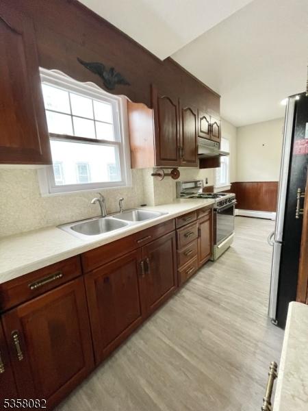 277 Watchung Ave, North Plainfield Boro, NJ 07060 - kitchen with range with gas stovetop, freestanding refrigerator, under cabinet range hood, a sink, and light countertops