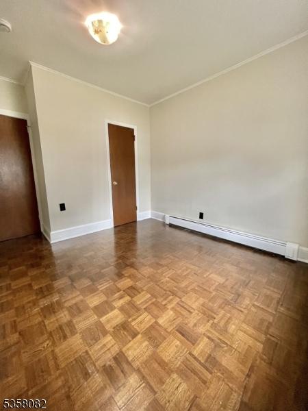 277 Watchung Ave, North Plainfield Boro, NJ 07060 - spare room featuring a baseboard radiator, crown molding, and baseboards