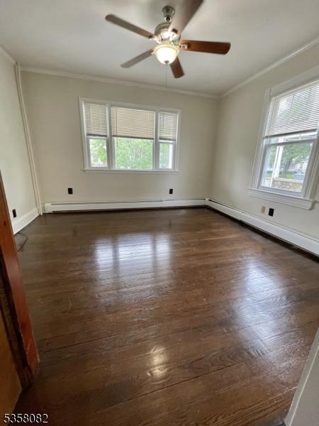 277 Watchung Ave, North Plainfield Boro, NJ 07060 - empty room featuring healthy amount of natural light, crown molding, ceiling fan, dark wood-style flooring, and a baseboard radiator