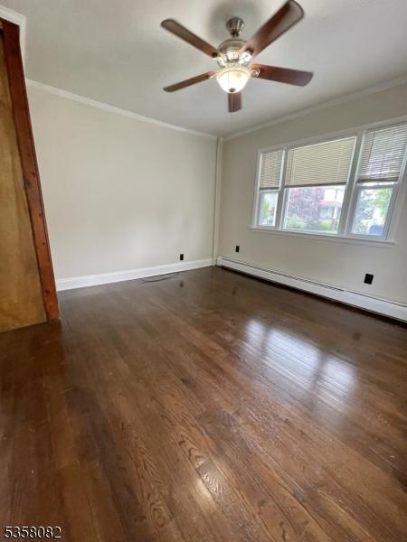 277 Watchung Ave, North Plainfield Boro, NJ 07060 - spare room with a baseboard heating unit, ornamental molding, a ceiling fan, wood finished floors, and baseboards