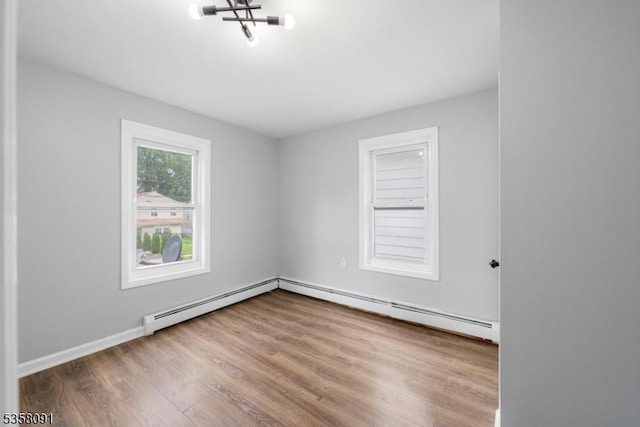 1353 W 3rd St, Plainfield City, NJ 07063 - unfurnished room featuring wood finished floors, a baseboard heating unit, a chandelier, and baseboards