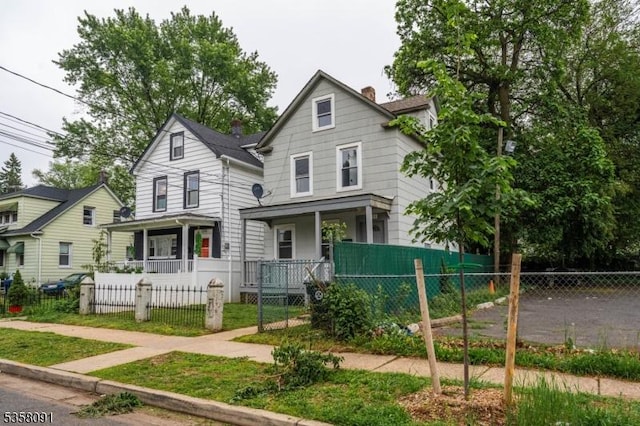 1353 W 3rd St, Plainfield City, NJ 07063 - view of front of home featuring a porch, a fenced front yard, and a chimney