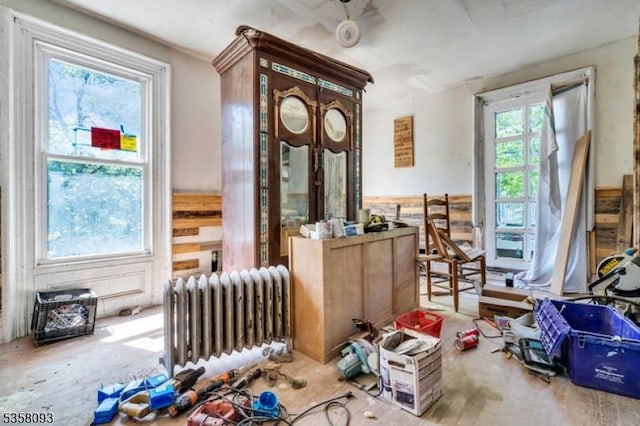 miscellaneous room with radiator heating unit and a wainscoted wall