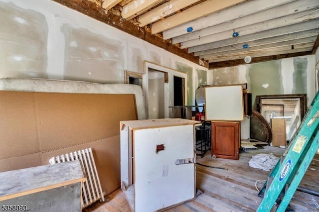 below grade area featuring radiator heating unit and wood finished floors