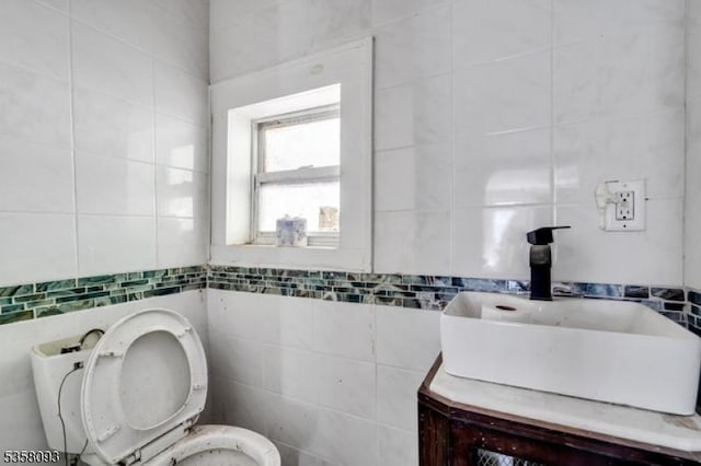 bathroom featuring tile walls, toilet, and vanity