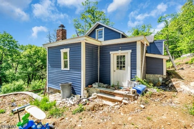 rear view of house featuring a chimney
