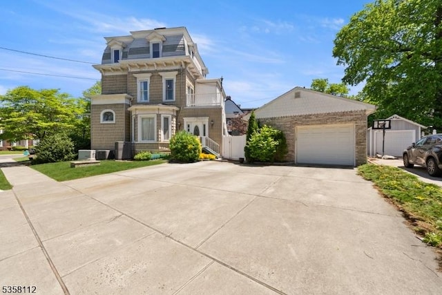 208 W Milton Ave, Rahway City, NJ 07065 - victorian home featuring a balcony, a garage, mansard roof, concrete driveway, and central AC unit