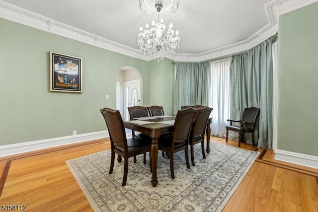 208 W Milton Ave, Rahway City, NJ 07065 - dining space with arched walkways, baseboards, ornamental molding, a chandelier, and wood finished floors