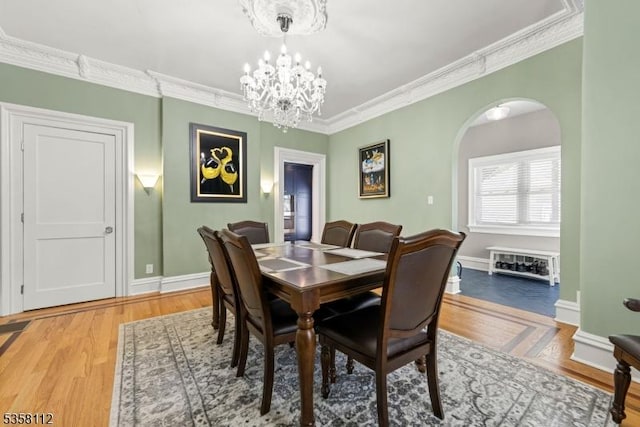 208 W Milton Ave, Rahway City, NJ 07065 - dining area with arched walkways, a chandelier, crown molding, wood finished floors, and baseboards
