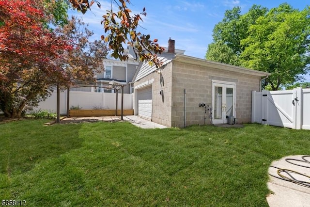 208 W Milton Ave, Rahway City, NJ 07065 - back of property featuring a gate, concrete block siding, a chimney, and a garage
