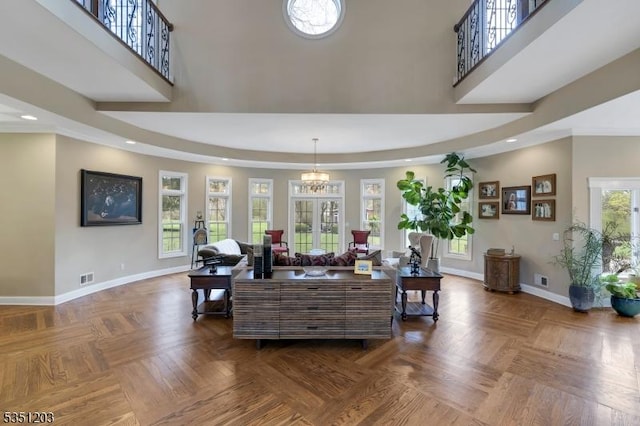 living area with baseboards, a high ceiling, and recessed lighting
