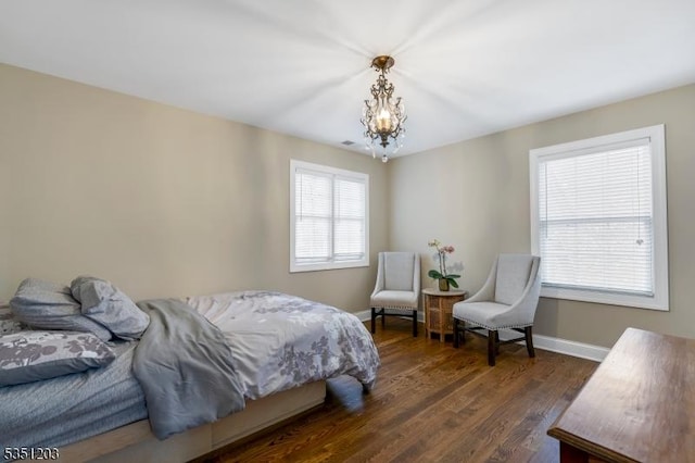 bedroom with a chandelier, baseboards, and dark wood-type flooring