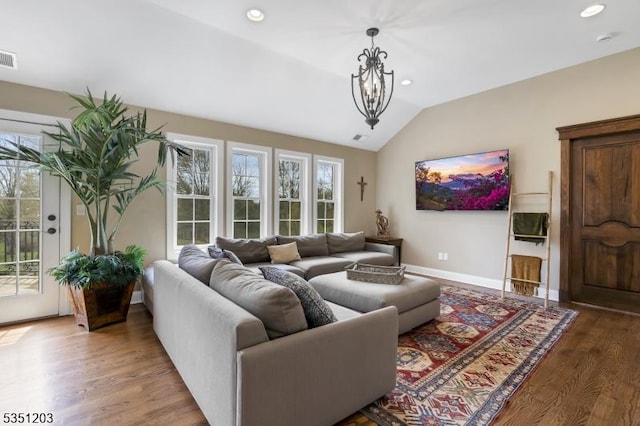 living area featuring vaulted ceiling, wood finished floors, baseboards, recessed lighting, and a chandelier