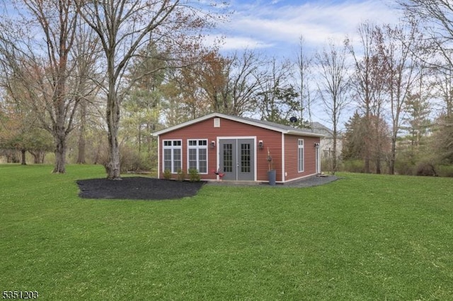 rear view of property with french doors and a yard