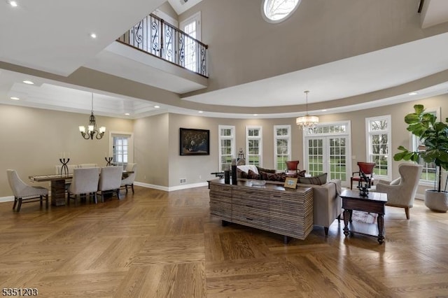 living room featuring a chandelier, baseboards, a towering ceiling, and recessed lighting