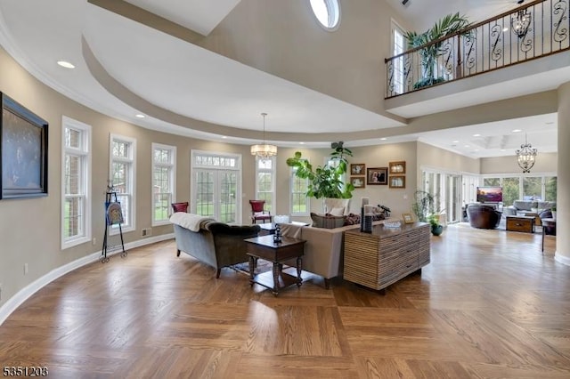 living area with a chandelier, baseboards, recessed lighting, and a tray ceiling