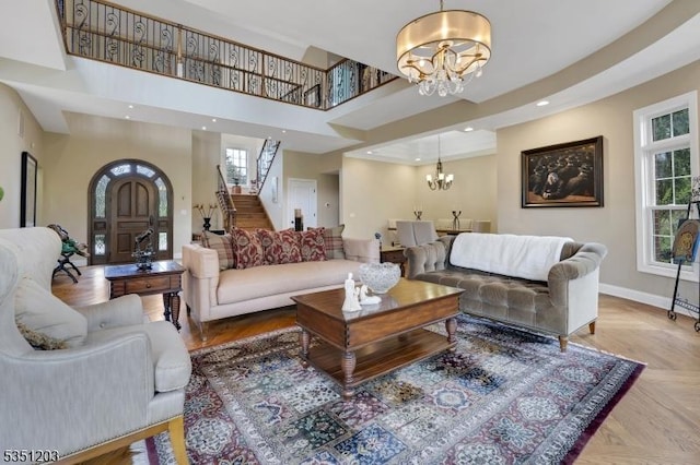 living room featuring a chandelier, stairs, baseboards, a high ceiling, and recessed lighting