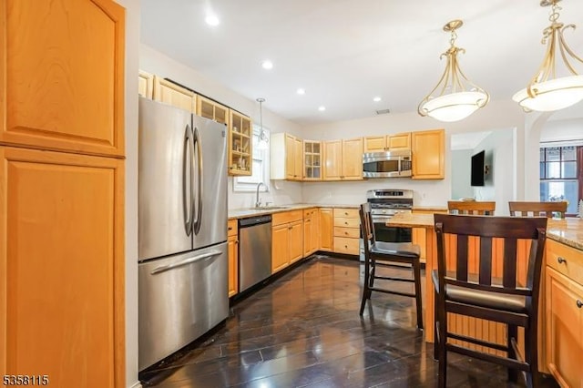 kitchen with stainless steel appliances, a sink, light countertops, glass insert cabinets, and recessed lighting