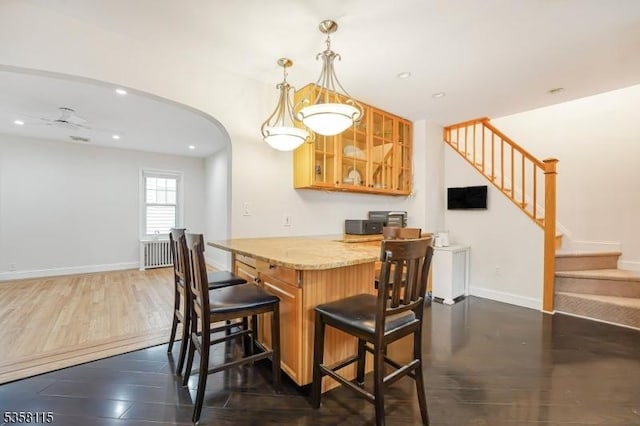 dining area with stairway, recessed lighting, a bar, arched walkways, and baseboards