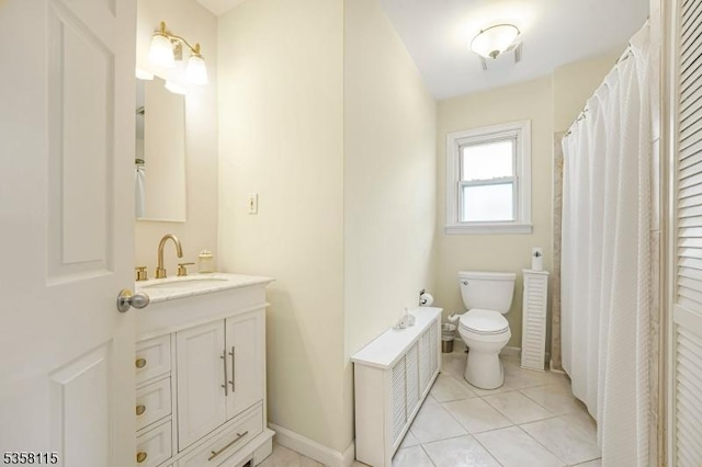 bathroom with toilet, vanity, tile patterned floors, and baseboards