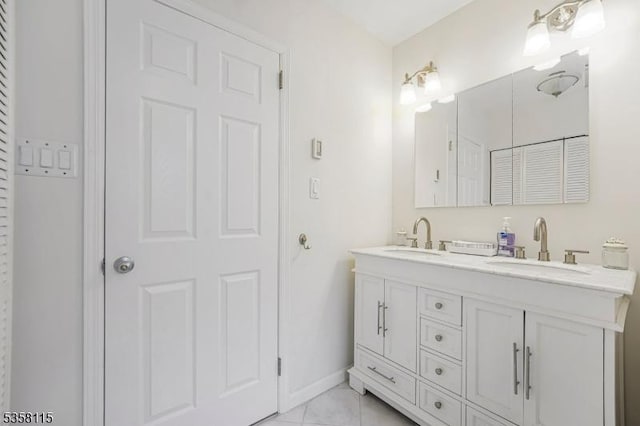 full bathroom featuring double vanity and baseboards