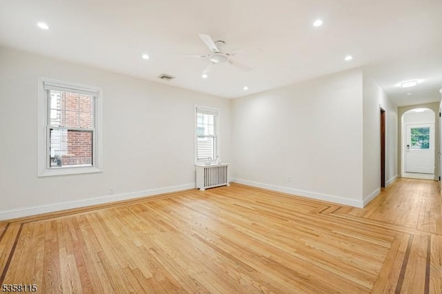 spare room with radiator heating unit, baseboards, ceiling fan, healthy amount of natural light, and recessed lighting