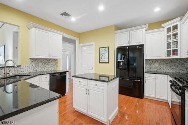 kitchen featuring black appliances, a sink, white cabinetry, and recessed lighting