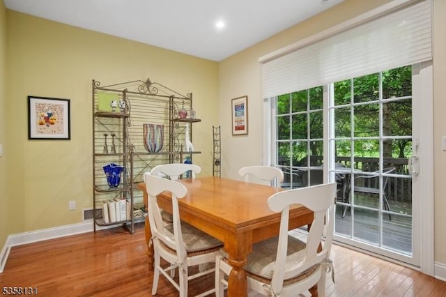 dining space featuring wood finished floors, baseboards, and recessed lighting