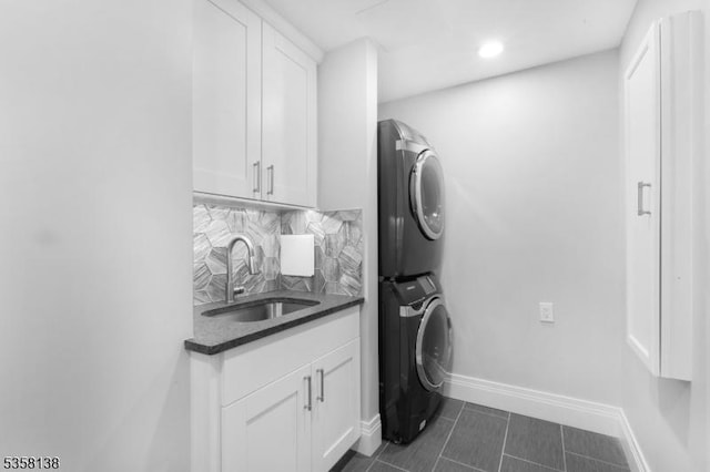 19 Village Way Unit 7H, Vernon Twp, NJ 07462 - laundry room featuring stacked washing machine and dryer, wet bar, baseboards, dark tile patterned floors, and cabinet space