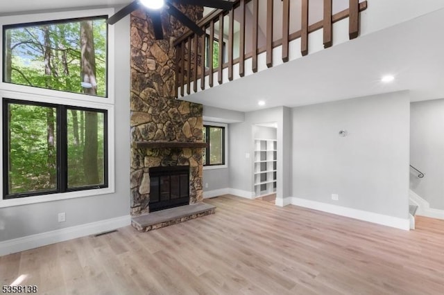 19 Village Way Unit 7H, Vernon Twp, NJ 07462 - unfurnished living room featuring baseboards, a fireplace, plenty of natural light, stairway, and a towering ceiling