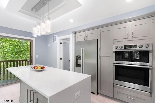 19 Village Way Unit 7H, Vernon Twp, NJ 07462 - kitchen with stainless steel appliances, a tray ceiling, a chandelier, a center island, and light countertops