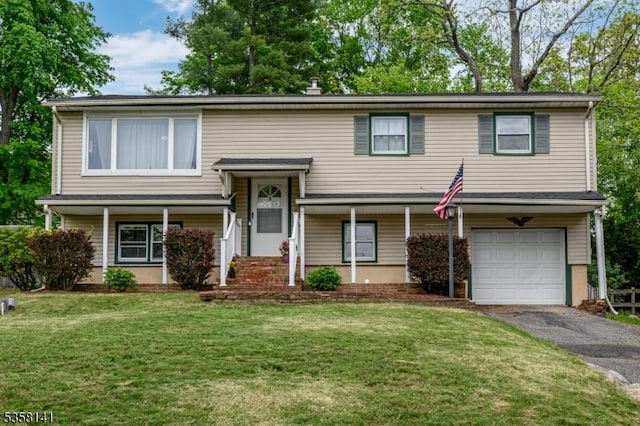 bi-level home featuring a garage, asphalt driveway, a front lawn, and covered porch