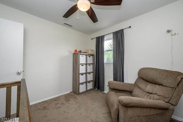 living area with carpet floors, ceiling fan, and baseboards