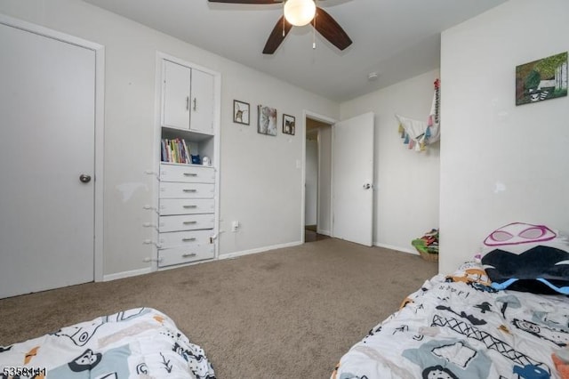 carpeted bedroom with ceiling fan and baseboards
