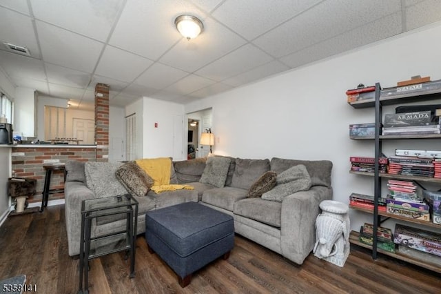 living room featuring a drop ceiling and wood finished floors