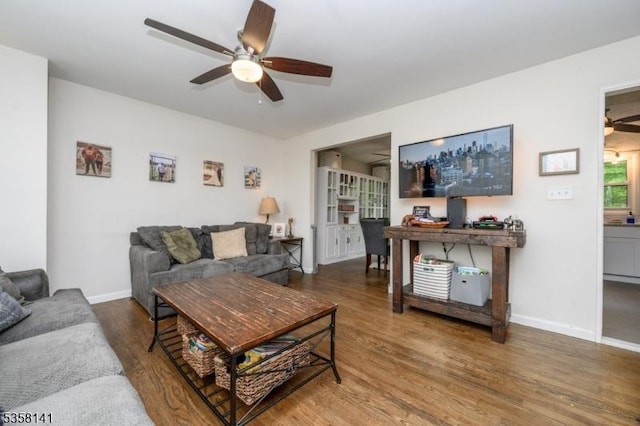 living room featuring a ceiling fan, wood finished floors, and baseboards