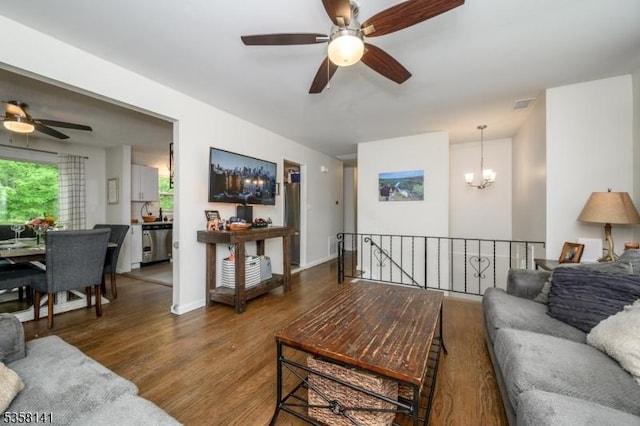 living room featuring ceiling fan, wood finished floors, and a chandelier