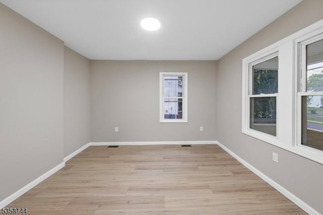 spare room with light wood-style floors and baseboards