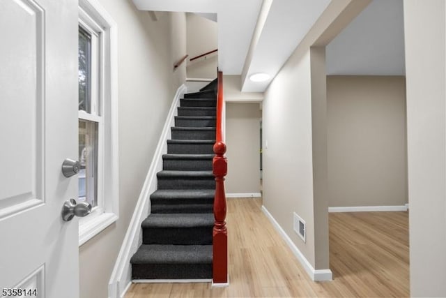 stairs featuring wood finished floors and baseboards