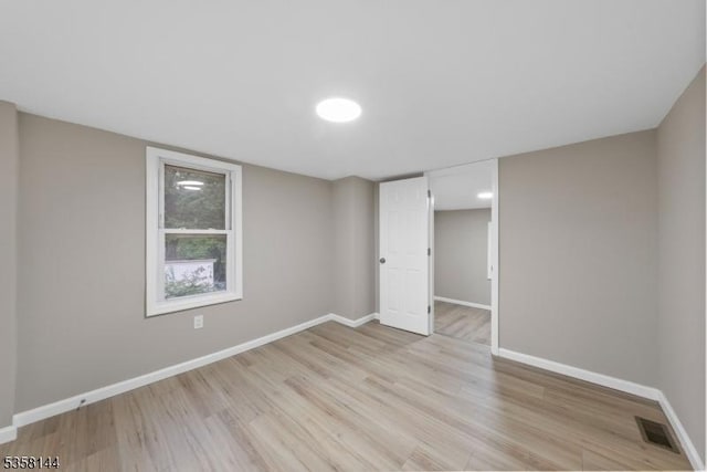 unfurnished bedroom with baseboards and light wood-type flooring
