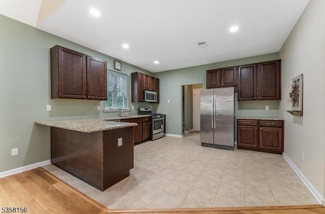 109 Samson Dr, Raritan Twp, NJ 08822 - kitchen featuring stainless steel appliances, a peninsula, dark brown cabinetry, baseboards, and light stone countertops