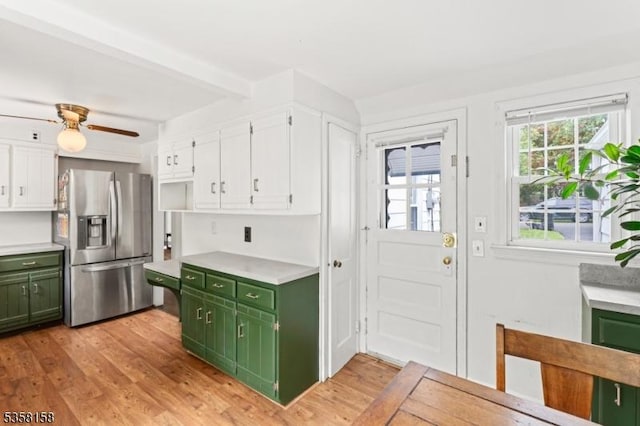 kitchen featuring green cabinetry, stainless steel refrigerator with ice dispenser, white cabinetry, light countertops, and beamed ceiling