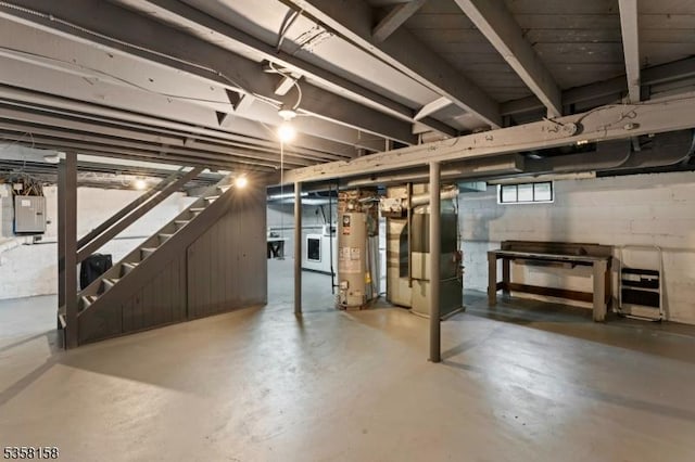 below grade area with gas water heater, electric panel, washer / dryer, heating unit, and stairway